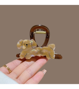 Detailed close-up of a pearlescent cartoon puppy hair claw clip with a brown base