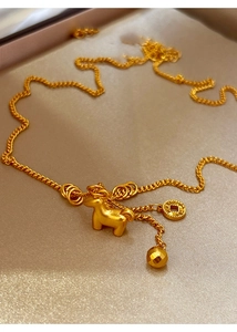 Macro detail of a 24K gold-plated necklace featuring a 3D horse pendant and coin charm