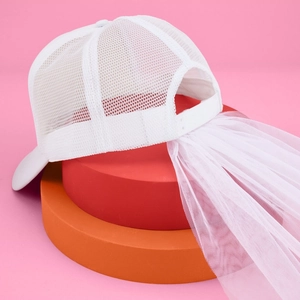 White bridal baseball cap with wedding veil on stylish display platforms for bachelorette party