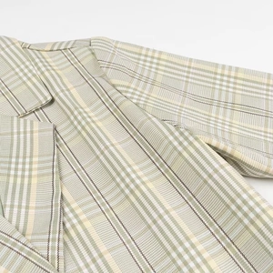 Detail view of the green plaid blazer notch lapel and shoulder seam stitching