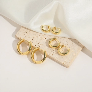 Three pairs of polished gold C-shaped hoop earrings in small, medium, and large sizes