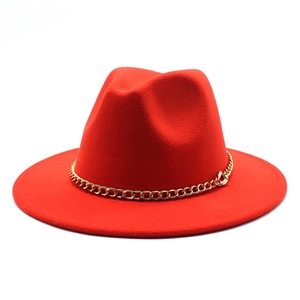 Detail of a red wool felt fedora hat with a decorative gold chain band accessory.