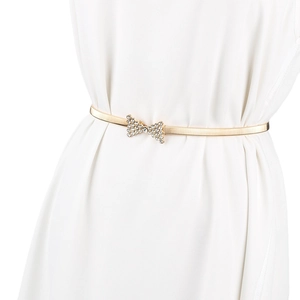 Gros plan sur la ceinture dorée élastique à ressort avec boucle nœud en strass brillant