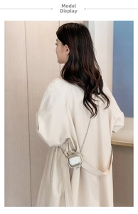 Silver metallic mini suitcase chain bag shown on a beige trench coat for women