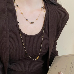 Detail of vintage tiger eye beaded layered necklace on a brown ribbed sweater outfit