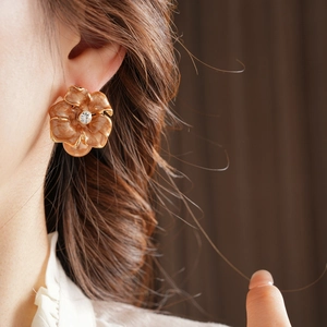Vue détaillée de la boucle d'oreille fleur en émail marron avec centre en cristal