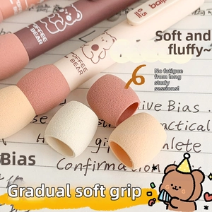 Close-up of soft gradient sponge pen grip in cream and pink on a writing notebook