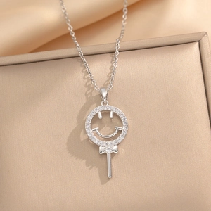 Collier sucette smiley en acier titane argenté avec détails en zircon et nœud