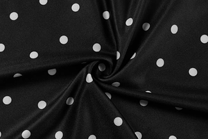 Macro shot of black polka dot fabric showing detailed twill texture and drape