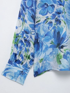 Detailed macro view of the floral print fabric and cuff on a bohemian long-sleeved blouse