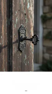 Macro detail of a vintage cast iron key-shaped handle mounted on rustic weathered wood