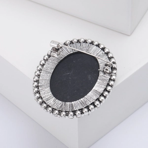 Detailed macro view of the silver metal brooch back with secure pin clasp and bead trim