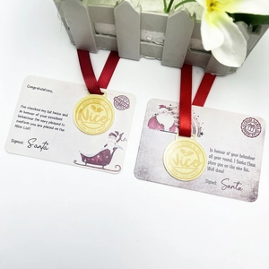 Christmas Nice List certificate set with golden medals and festive red ribbons on white wood