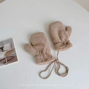 Close-up of soft brown plush winter mittens for kids featuring a neck string attachment