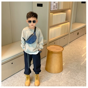 Toddler blue denim crossbody bag shown on model wearing casual outfit for style and size