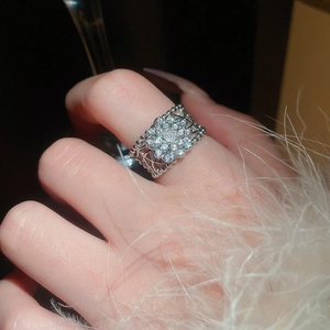 Vue rapprochée d'une bague fleur argentée ajourée avec zircons brillants sur la main