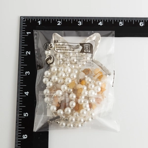 Macro shot of multi-layer star pendant necklace with pearls and turquoise beads in packaging