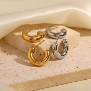 Minimalist C-shaped hollow hoop earrings in gold and silver finish on marble background