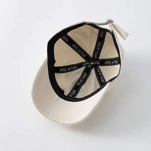Interior view of beige cotton baseball cap featuring reinforced branded inner seam tapes