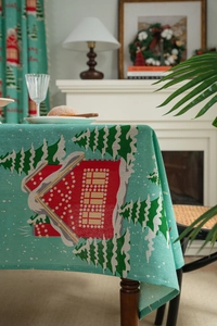 Detail of turquoise cotton linen tablecloth with red house and snow pine patterns