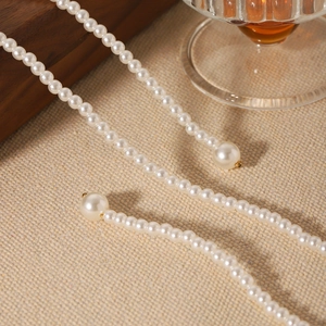 French vintage multi-layer pearl necklace with elegant round beads on woven background