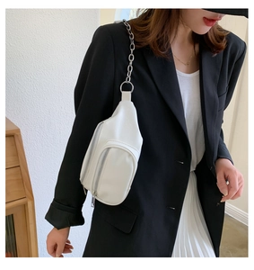Detailed view of white PU fanny pack featuring silver metal zipper and elegant chain strap