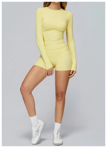 Vista completa del set da yoga giallo con pantaloncini a vita alta e maglia a maniche lunghe