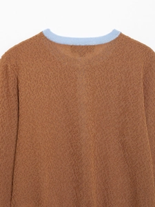 Detail des Rundhalsausschnitts mit blauem Kontrast an einer braunen Strickjacke