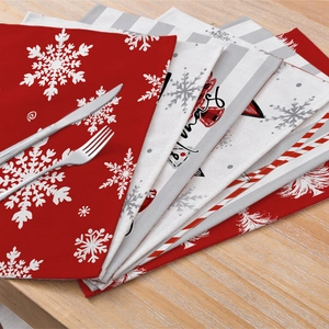 Christmas placemats with snowflake prints and red stripes on a wooden dining table