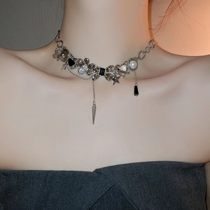 Silver punk choker featuring black heart, star, and pearl charms in a close-up detail shot