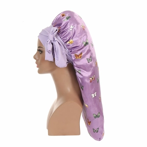 Detail view of purple butterfly print satin bonnet with long tail and bow tie on model head