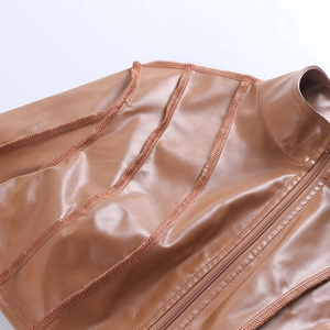 Close-up of brown leather jacket shoulder with reinforced stitching and zipper detail