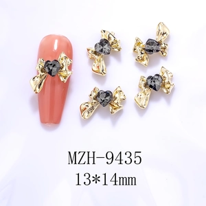 Detailed view of 13x14mm golden alloy bow nail art charm with a dark grey heart crystal