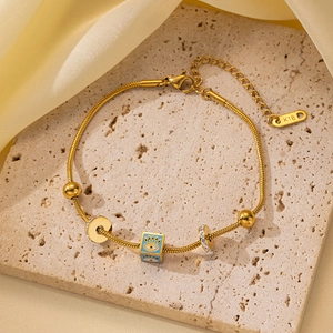 Detalle de pulsera de cadena de serpiente oro 18K con colgante de ojo de la suerte
