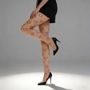 Close-up of sheer black pantyhose with heart pattern and pointed high heels