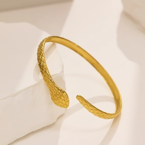 Detail of 18k gold-plated snake cuff bracelet showing intricate scale texture and design