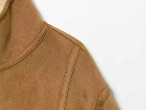 Detailaufnahme des Kragens einer braunen Wildlederjacke mit feinen Nähten und Textur