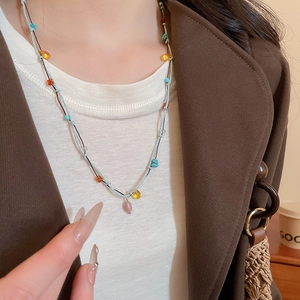 Detailed view of hand-woven colorful bead necklace featuring natural stone accents