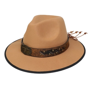 Close-up of Western felt cowboy hat with bull head emblem, metal rivets and leather tassels