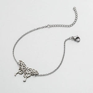 Detailed close-up of a silver hollow butterfly pendant on a polished metal chain bracelet