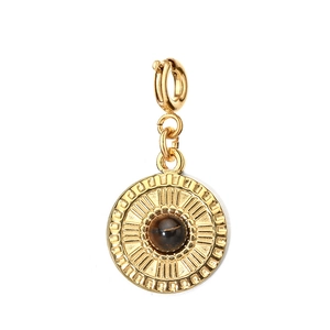 Macro detail of golden circular pendant with brown tiger eye stone and radial texture