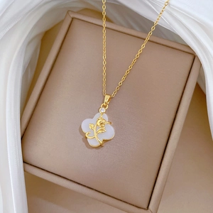 Detail of gold clover necklace with tulip pattern and micro-set diamond on jewelry box