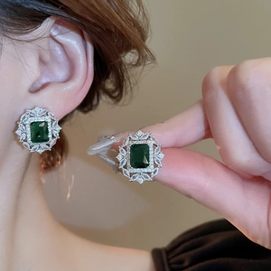 Vista macro di orecchini vintage francesi con zircone verde smeraldo e finitura argento
