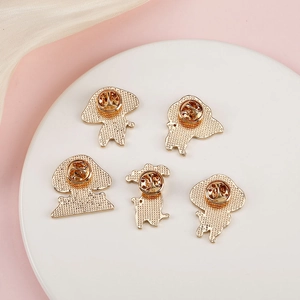 Detail view of five golden metal butterfly clutch backings for animal pins on silk