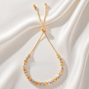 Detailed view of tricolor faceted metal beads on a gold bolo adjustable bracelet