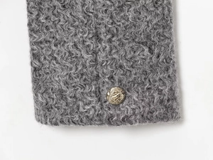 Gros plan détaillé du manteau en laine gris foncé avec bouton en métal doré texturé