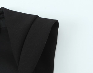 Detailed close-up of premium black twill fabric and high-quality tailoring on a romper