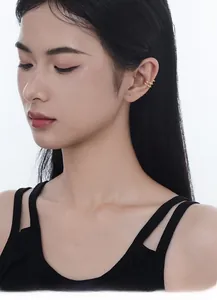 Close-up of minimalist double-loop gold ear cuff on female ear model in a macro view