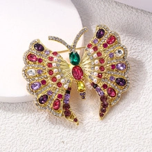 Detailed macro view of a golden butterfly napkin ring with colorful gems and pearls