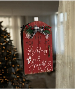 Red wooden sled Christmas sign with Merry & Bright text, pine branches, and a plaid bow